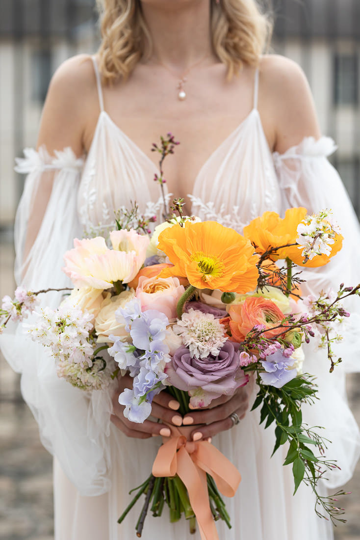 mariée romantique avec son bouquet de fleurs colorées